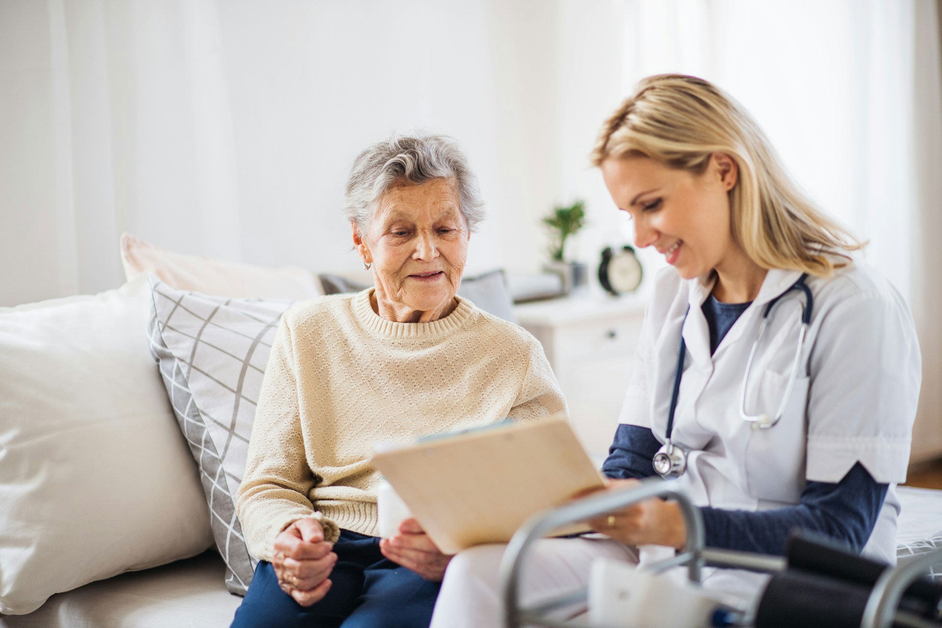 Female doctor sits with an elderly female patient reviewing her results