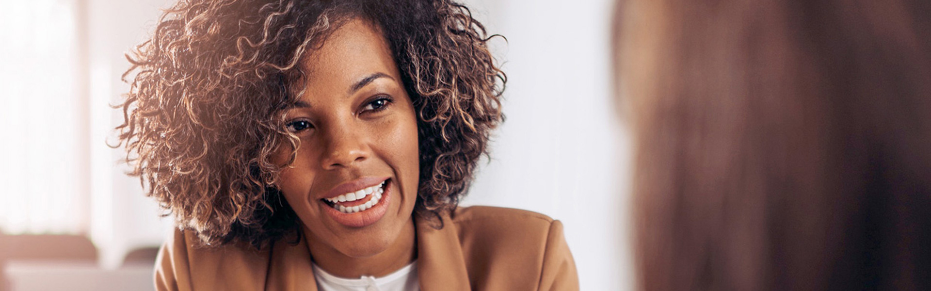African American female consultant smiles as she discusses Revenue Cycle Management with the practice owner
